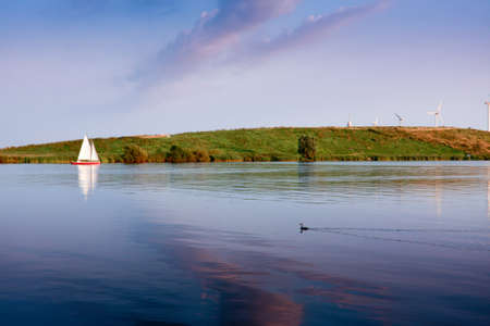 Sailing against wind turbines a quiet evening