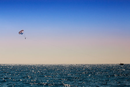 parasailing man over blue seaの写真素材