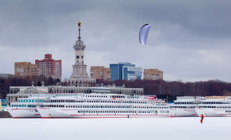 Winter snowkiting at Moscow North River Port and ships behind kiteboarderの写真素材