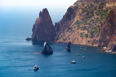 Rocks and boats at Crimea rugged sea coastの写真素材