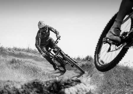 Russia, Moscow - April 29, 2012: Mountainbiker rides on hill path at summerKAT 2012 competition, black and whiteのeditorial素材