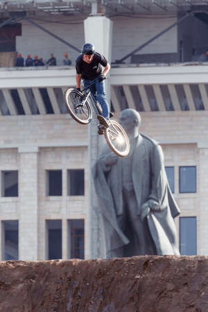 Russia, Moscow, July 23, 2016: Mountainbiker makes a stunt in front of Lenin monument at Moscow City Games contest, Luzhniki, Moscow, Russiaのeditorial素材
