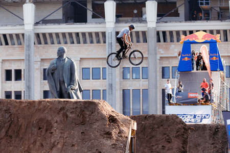 Russia, Moscow, July 23, 2016: Mountainbiker makes a trick in front of Lenin monument at Moscow City Games contest, Luzhniki, Moscow, Russiaのeditorial素材