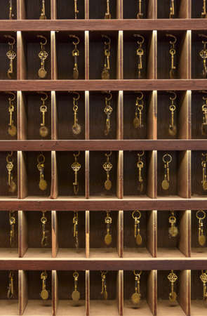 Retro keys in wooden storage, hotel reception, old vintage style, all keys in a placeの写真素材