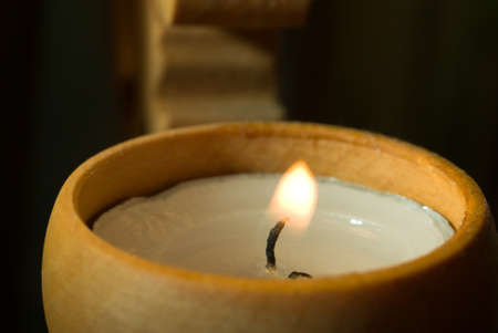 candle in a simple wooden candlestickの写真素材