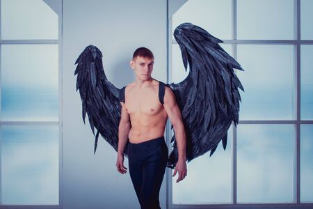 the man with the black wings of a fallen angelの写真素材