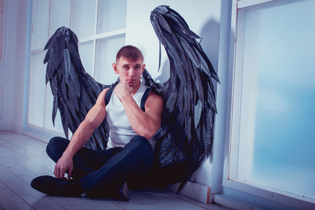 the man with the black wings of a fallen angelの写真素材