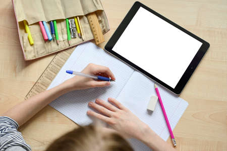 Online home lesson. Blank for your text. Children's hands in the frame. School supplies. Social distance.の写真素材