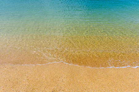 the sea washes the sandy beach. Clear transparent turquoise sea on a sandy beach
