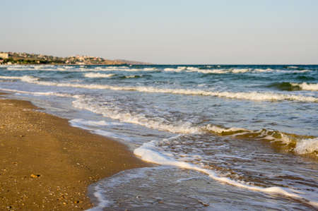 Sea waves in the morning. The sandy beach is washed by sea waves. Focusing on the foreground.の写真素材