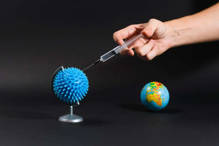 Globe Coronovirus Shape Black Background Human Hand Vaccine Injection In the background there is a...