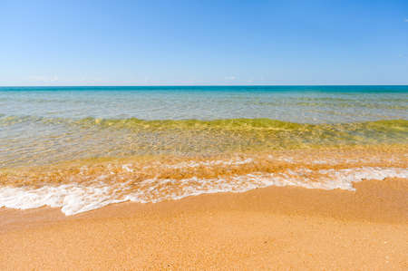 Seashore on a sunny day. Background on the theme of the sea and relaxation. Focusing on the water's edge.の写真素材