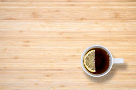 A cup of black tea with lemon on a wooden table. View from above. There is a free space.の写真素材