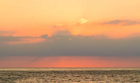 The sky is orange during sunset over the calm sea. Sunset over the sea.の写真素材