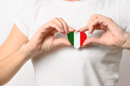 Love Italy. The girl holds on her chest in her hands a heart in the form of the flag of Italy. The concept of Italian patriotismの写真素材
