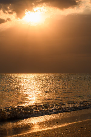 Black Sea coast during golden sunset. Vertical landscape. Focusing in the center of the frame on the sea surface.の写真素材