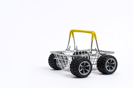 Empty supermarket shopping cart with wheels from a car on a white background. The concept of fast delivery of goods for online shopping.の写真素材