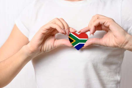 Love South Africa. The girl holds a heart in the form of the flag of South Africa on her chest. South African concept of patriotismの写真素材