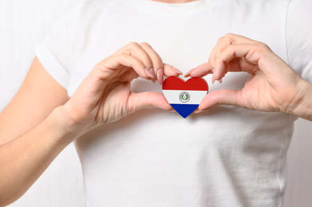 Love Paraguay. The girl holds a heart in the form of the flag of Paraguay on her chest. Paraguayan patriotism conceptの写真素材