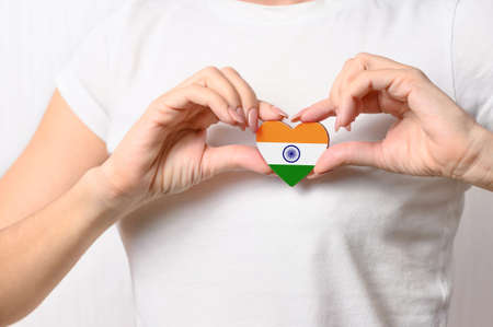 Love India. The girl holds a heart in the form of the flag of India on her chest. Indian patriotism conceptの写真素材