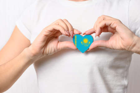 Love Kazakhstan. The girl holds a heart in the form of the flag of Kazakhstan on her chest. Kazakh patriotism conceptの写真素材