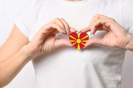 Love Macedonia. The girl holds a heart in the form of the flag of Macedonia on her chest. Macedonian patriotism conceptの写真素材