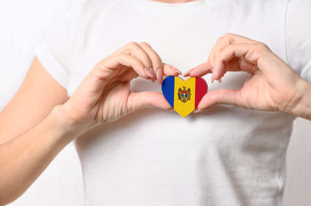 Love Moldova. The girl holds a heart in the form of the flag of Moldova on her chest. Moldovan patriotism conceptの写真素材