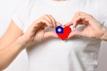 Love Taiwan (Republic of China). A girl holds a heart in the form of a flag of Taiwan on her chest. Taiwanese patriotism conceptの写真素材