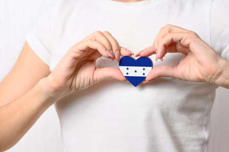 Love Honduras. The girl holds a heart in the form of the flag of India on her chest. Honduran patriotism conceptの写真素材
