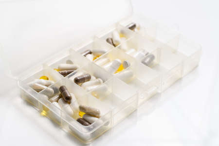 The pills are in a plastic box. Medicines for daily use are sorted by dose in an organizer....