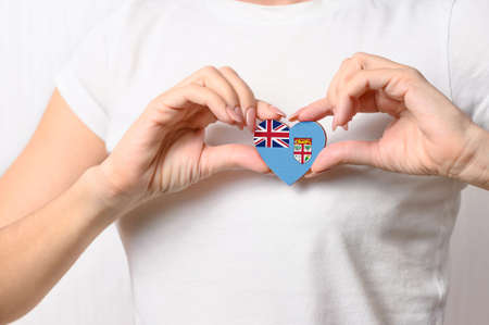Flag of Fiji in the shape of a heart in the hands of a girl. Love Fiji. The concept of patriotism and tourismの写真素材