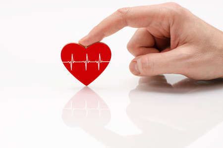 Red heart with a white line of the pulse in a man's hand on a white background. Cardiac disease treatment concept.の写真素材