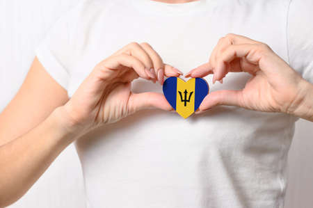 Flag of Barbados in the shape of a heart in the hands of a girl. Love Barbados. The concept of patriotism and tourismの写真素材
