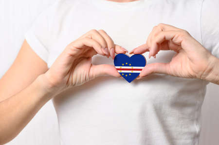 Cape Verde flag in the shape of a heart in the hands of a girl. Love Cabo Verde. Cabo Verde patriotism and tourism conceptの写真素材