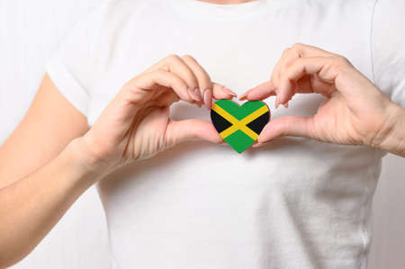 Flag of Jamaica in the shape of a heart in the hands of a girl. Love Jamaica. The concept of patriotism and tourism for Jamaicaの写真素材