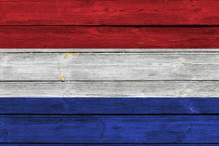 Netherlands flag on an old wooden surface with cracked paint.の写真素材