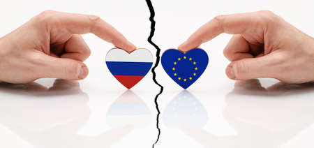 Concept of disagreement between the EU and Russia. Flags of the European Union and Russia in the shape of a heart in hand.の写真素材