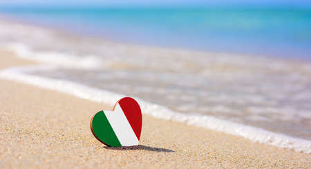 Flag of Italy in the shape of a heart on a sandy beach. The concept of the best vacation in Italyの写真素材