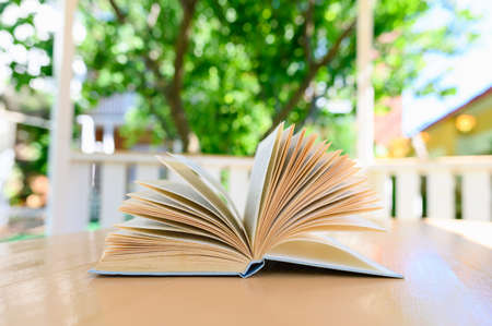 The open book lies in the summer pavilion. Shallow depth of sharpness.の写真素材