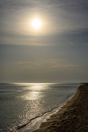 Vertical dark seascape with sunlight and highlights on the water. Selective focus on the horizon.の写真素材