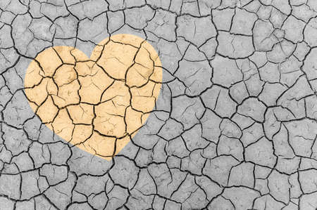 The concept of protecting the world from global warming. Heart sign on dry cracked ground.の写真素材