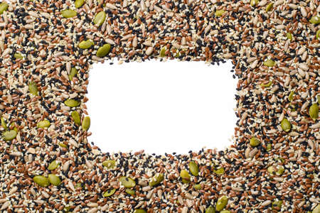 A frame made from a mixture of seeds. There is an empty white space in the center. View from above