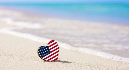 Flag of the USA Islands in the shape of a heart on a sandy beach. The concept of the best vacation in USAの写真素材