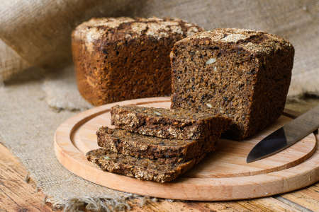 Fresh sourdough rye bread on a wooden board and cloth.の写真素材