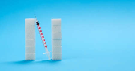 Blue banner with a large letter N made from sugar cubes and an insulin syringe. Diabetes protection conceptの写真素材