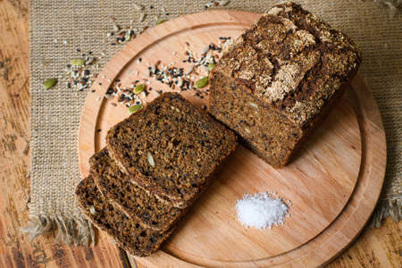 Rye-free rye bread sliced ââwith salt on a wooden board. View from above. Healthy food concept.の写真素材