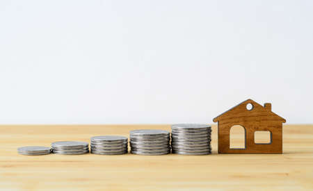 Keys to a new house with a house-shaped keyring on a wooden background.の写真素材