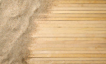 Sea sand on a wooden background. Top view, empty space on the right.の写真素材