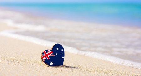 Flag of Australia in the shape of a heart on a sandy beach.の写真素材