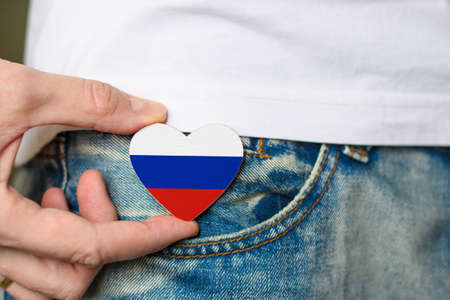 Patriot of the Russia! Wooden badge with Russia flag in the shape of a heart in a man's hand.の写真素材